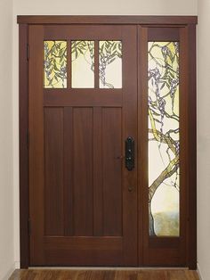 a wooden door with stained glass panels on the front and side doors in an empty room