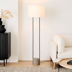 a living room with a white couch and black lamp