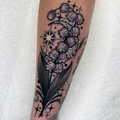 a woman's leg with a feather and flowers tattoo on her left calf area