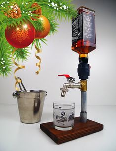 an image of a bottle and glass on a stand next to a christmas ornament