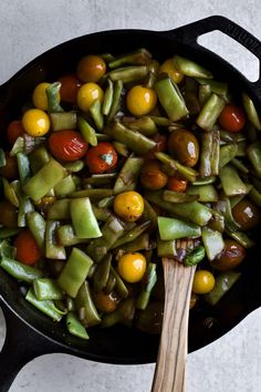 a skillet filled with green beans and tomatoes