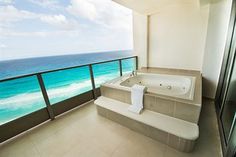 a large bath tub sitting on top of a balcony next to an ocean front building