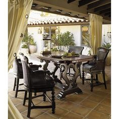 a dining room table with chairs and a vase on the table in front of it