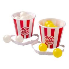 two red and white striped popcorn buckets filled with yellow balls, one in the middle