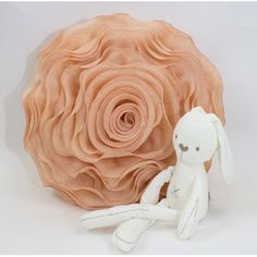 a stuffed animal sitting next to a large flower