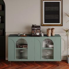 a green cabinet with two glass doors in the middle and a coffee maker on top