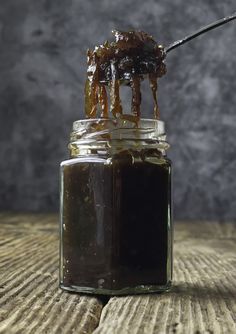 a jar filled with caramel sauce on top of a wooden table