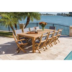 an outdoor dining table with six chairs next to a swimming pool