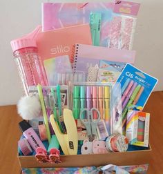 a box filled with school supplies on top of a wooden table