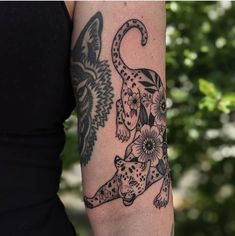 a woman with a tattoo on her arm has a leopard and flower design on it