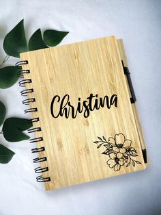 a wooden notebook with the word christma written in cursive writing on it