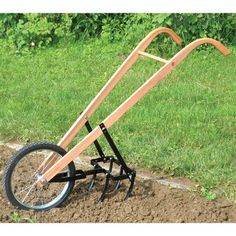 a wooden wheelbarrow is sitting in the dirt