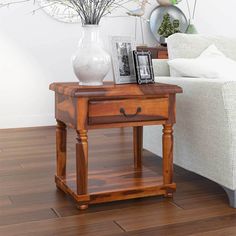 a wooden table sitting on top of a hard wood floor next to a white couch