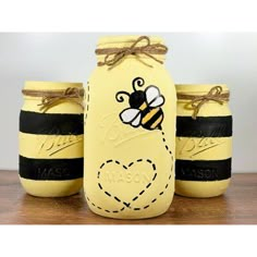 three mason jars with bees painted on them