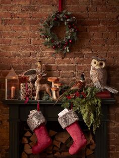 an owl sitting on top of a mantle next to a christmas stocking filled with decorations