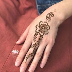 a woman's hand with henna tattoos on it