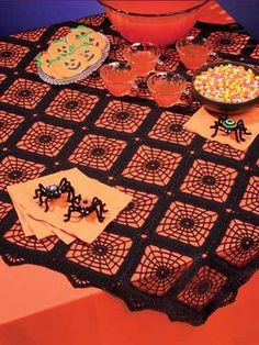 an orange table with black doily on it and some desserts in the bowl