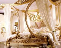 an ornate gold bed with white drapes and flowers on the floor