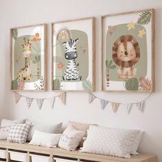 three framed pictures hang on the wall above a wooden bench with pillows and blankets underneath them