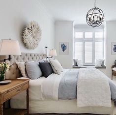 a bedroom with white walls and carpeted flooring has a large bed in front of a window