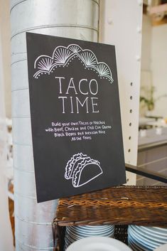 a sign that says taco time on it next to plates and bowls in a kitchen