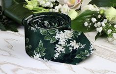 a green tie with white flowers on it