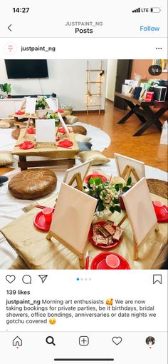 the table is set up with red plates and place settings for guests to sit at