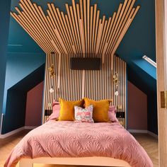 a bedroom with blue walls and wooden slats on the headboard, along with pink bedding