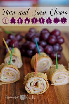 ham and swiss cheese pinwheels on a cutting board with grapes