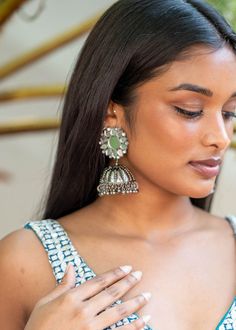 The Sanjana Earrings are silver floral mirror jhumkas! Pair these silver plated earrings with your modern and traditional lehengas to add a rich and elegant look to your attire at any time. Mirror Work Chandbali Jhumkas, Silver Chandbalis With Mirror Work, Chandbali Jhumkas With Mirror Work, Elegant Silver Chandbalis With Mirror Work, Festive Fusion Earrings With Mirror Work, Chandbali Mirror Work Jhumkas, Silver Party Danglers With Cutdana, Silver Danglers With Mirror Work For Wedding, Silver Danglers With Cutdana For Party