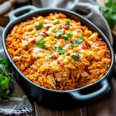 mexican rice with corn and cilantro in a black skillet on a wooden table