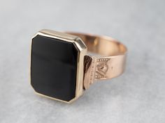 "Crafted by our master metalsmiths this is a stunning one-of-a-kind unisex piece! We've taken an antique rose gold victorian band featuring classic motifs and attached a stately cushion cut black onyx cabochon in a sleek bezel of yellow gold from the early mid-century. Perfectly stylized and sized for him or her, this is a stunning piece ready to wear or gift! Metal: 10K Antique Rose Gold, 14K Yellow Gold Gem: Black Onyx Gem Measurements: 13.3 x 11.2 mm, Rectangle Cushion Cut Ring Size: 10 Marks Victorian Black Engraved Ring In 14k Gold, Victorian Engraved Black Ring In 14k Gold, Black Victorian Rings With Black Enamel, Black Victorian Ring With Black Enamel, Black Victorian Rings With Polished Finish, Victorian Style Black Rings With Polished Finish, Victorian Black Rings With Polished Finish, Art Deco Onyx Ring With Black Enamel, Black Victorian Signet Ring For Formal Occasions