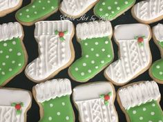 decorated cookies in the shape of christmas stockings and boots are displayed on a black surface