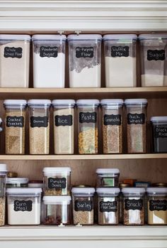 the shelves are filled with different types of spices and seasonings in glass containers, labeled with chalkboard labels