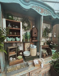 an old dresser with lots of pots and other items on it's top shelf