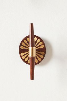 a wall mounted wooden clock on the side of a white wall