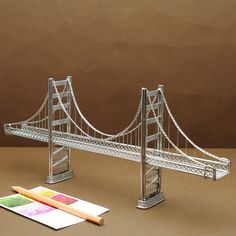 a miniature model of the golden gate bridge and some crayons on a table