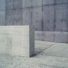 a concrete block sitting on top of a brick floor next to a wall with a skateboard in it