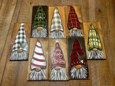 seven gnomes painted on wooden boards sitting on a table