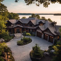 this is an aerial view of a large house on the water's edge at sunset