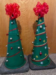 two green christmas trees with red bows on them