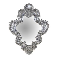 an ornate silver mirror on a white background