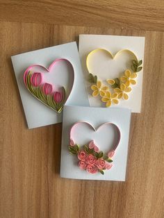 three greeting cards with flowers and hearts on them, one is made out of paper