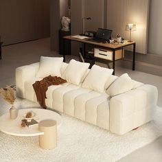 a large white couch sitting on top of a rug in front of a computer desk