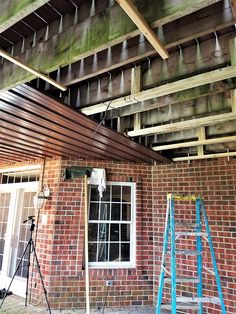 the roof is being installed on this brick building with wood slats hanging from it's rafters