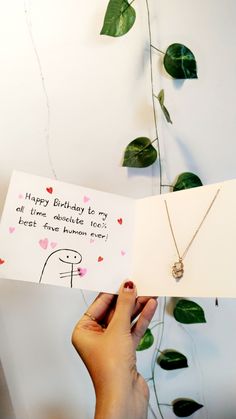 a person holding up a card with a happy birthday message on it