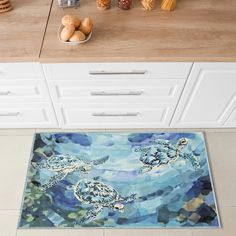 two sea turtles swimming in the ocean on a blue and white rug next to a counter