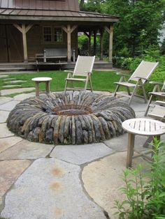 an outdoor fire pit with chairs around it