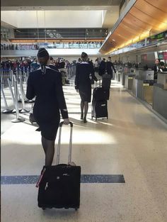 people walking through an airport with their luggage