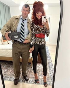 a man and woman standing in front of a mirror taking a selfie with their cell phones